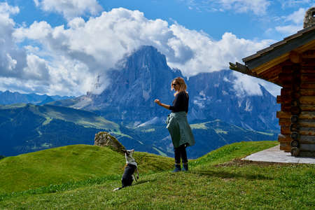 Young tourist walking the dog in the Dolomites mountainsの写真素材
