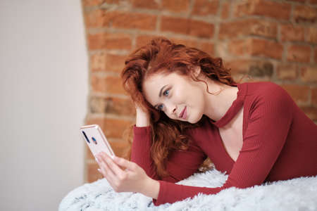Woman taking selfies at home Handsome Influencer women live streaming on her phone. Beauty socializing lifestyle concept. home workingの写真素材