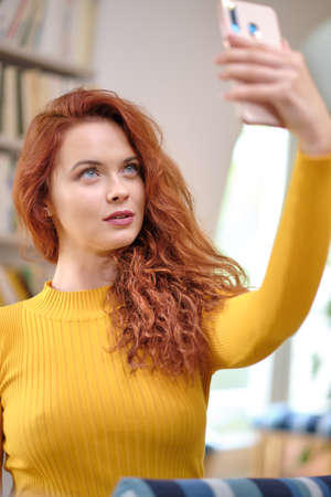 Woman taking selfies at home Handsome Influencer women live streaming on her phone. Beauty...