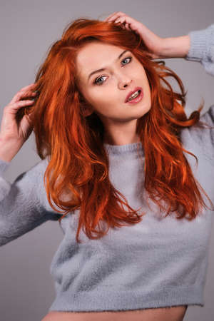 Young attractive redhead girl smiling looking at camera