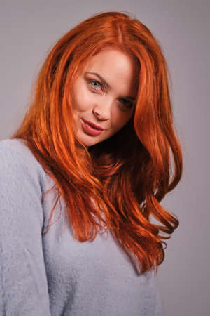 Young attractive redhead girl smiling looking at cameraの写真素材
