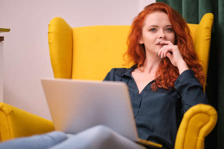 Redhead young woman using laptop at home. covid isolation. home officeの写真素材
