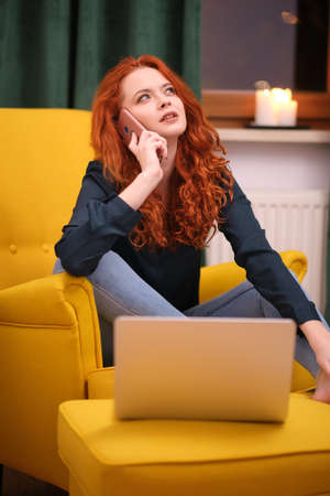 Redhead young woman using laptop at home. covid isolation. home officeの写真素材