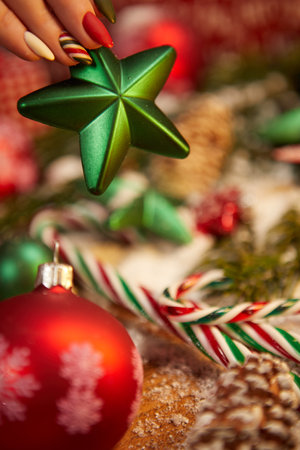 Woman with fancy x-mas manicure holding a green starの写真素材