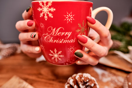 Christmas cup with tea in female handsの写真素材