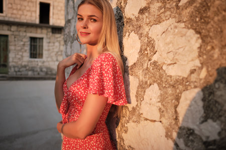 Traveling by Europe. Happy young woman in elegant dress walking by streets, Croatia.の写真素材