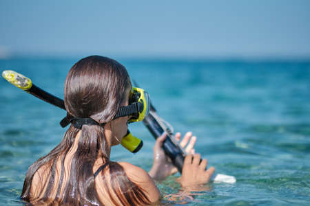 A woman in a bikini hunts with a crossbowの写真素材