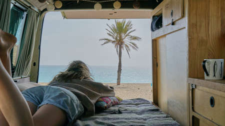 Vanlife, The girl is in the van watching the oceanの写真素材