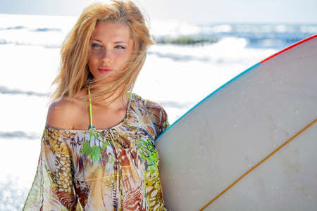 Beautiful female surfer with surfboard on a summer day.の写真素材