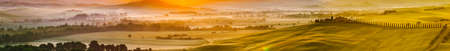 Tuscany, Italy landscape. Super high quality panorama taken at wonderful sunrise. Vineyards, hills, farm house.の写真素材