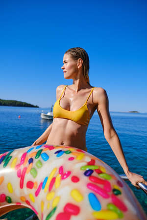 Happy smiling woman in bikini and sunhat on sea beachの写真素材