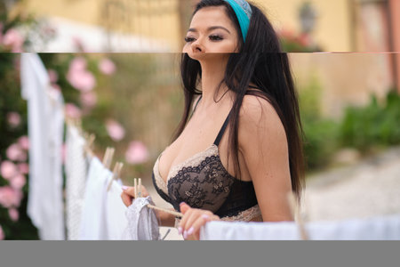 italian woman hangs up the laundry in gardenの写真素材