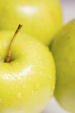 Group of green apples on glass surfaceの写真素材