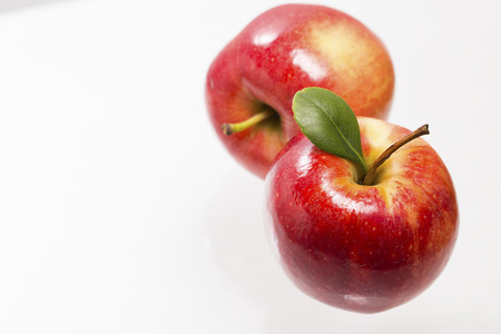 Two red apples on glass surfaceの写真素材