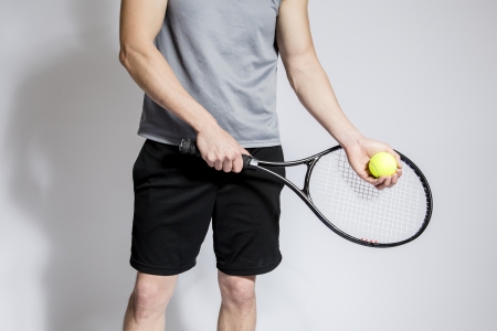Athletic male holding tennis raquet and ballの写真素材