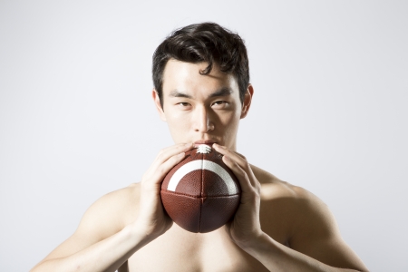 Shirtless athletic male holding footballの写真素材