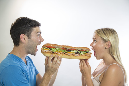 man and woman eating sandwichの写真素材