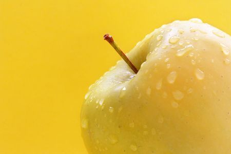 Granny smith apple isolated over yellow backgroundの写真素材