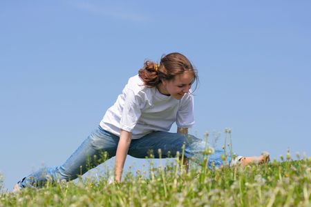 Teen girl to do exercises on the grassの写真素材