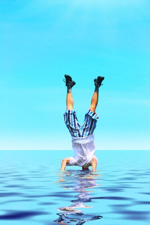 Crazy man stand upside down with head under water