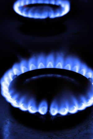Gas flame on burner close-up over black background