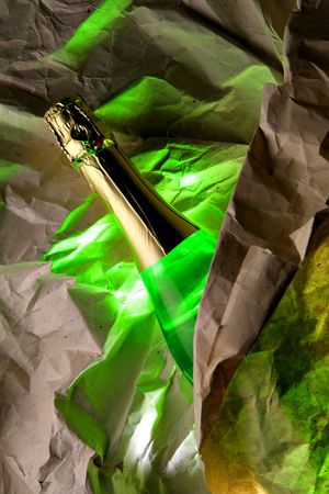 Bottle of champagne and crumpled warping paperの写真素材
