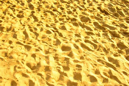 Lots of footprints on sand at crowded beach