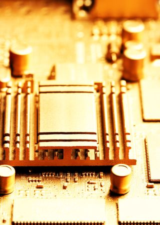 Gold circuit board with chip and radiator. Shallow DOF!