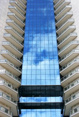 Perspective of tall modern building with sky reflectionの写真素材