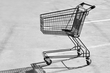 Single empty shopping cart on asphaltの写真素材