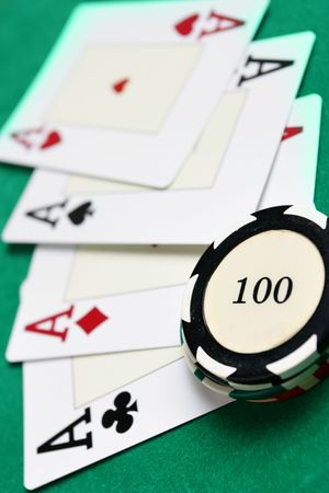 Casino chips and four aces on green table close-up. Shallow DOF!