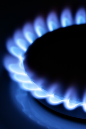 Blue gas flame on hob close up in the dark
