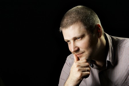 Thinking man close up over black background