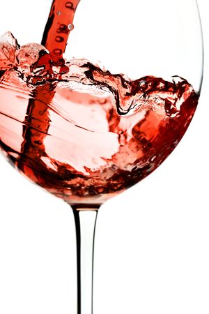 Red wine pour into glass close-up isolated over white background