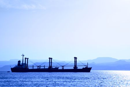 Cargo ship at the harbour. View from Jordan shore to Israelの写真素材