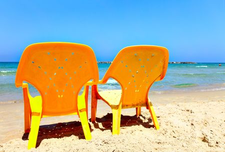 Two empty yellow chairs on beach close upの写真素材