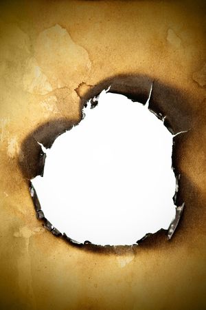Close-up of hole burnt through old yellow paperの写真素材
