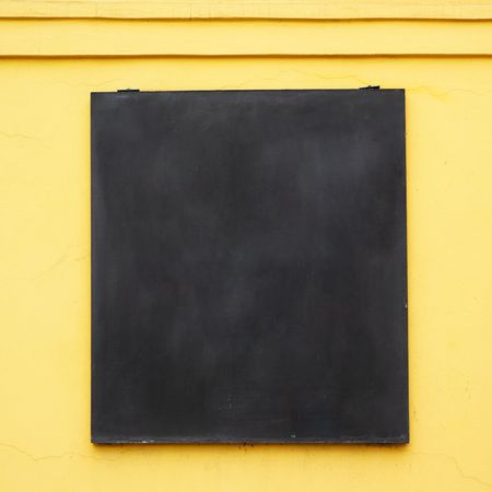 Blank menu board on yellow wall, put any text hereの写真素材