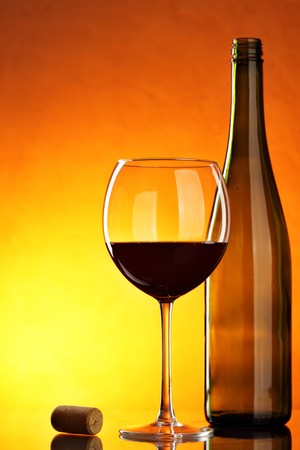 Still-life with glass and bottle of red wine on tableの写真素材