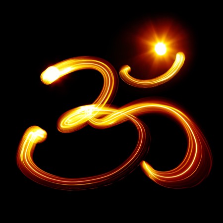 Sacred Om syllable created by light over black backgroundの写真素材