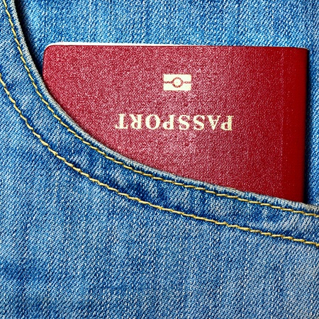 Red biometric passport in jeans pocket close-upの写真素材
