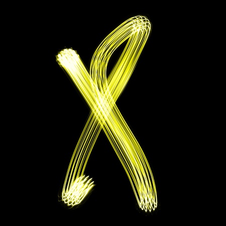 X - Created by light alphabet over black backgroundの写真素材