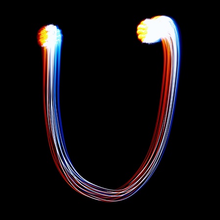 U - Created by light colorful letters over black backgroundの写真素材