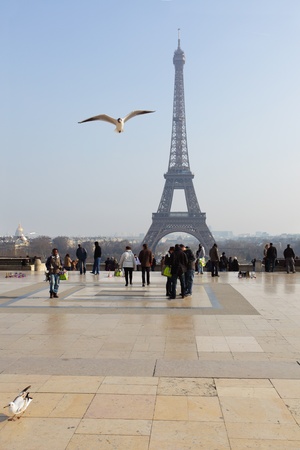 PARIS - MARCH 3: Tourists and small traders on viewing point near The Eiffel Tower; on March 3; 2011 in Paris; France. The Eiffel Tower is the most famous monument in Paris, averages over six million visitors per year.のeditorial素材