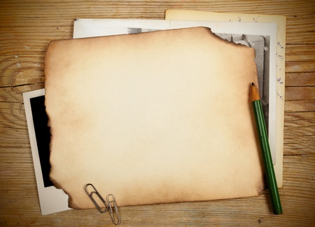 Stack of old papers and photos on a wooden tableの写真素材