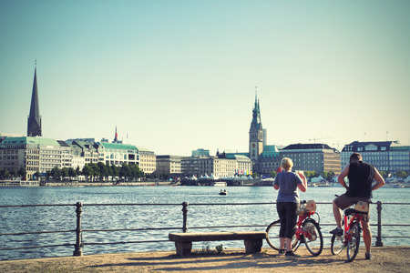 HAMBURG, GERMANY - AUGUST 19, 2012  Tourists on rented bicycles near Alster lake in Hamburg