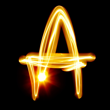A - Created by light alphabet over black backgroundの写真素材