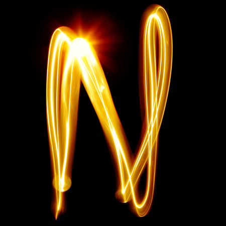 N - Created by light alphabet over black backgroundの写真素材