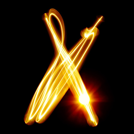 X - Created by light alphabet over black backgroundの写真素材