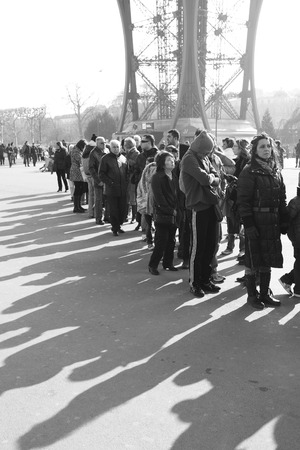 PARIS, FRANCE - March 3, 2011: Tourists and their shadows in a queue to The Eiffel Tower in Paris.  Black and white imageのeditorial素材